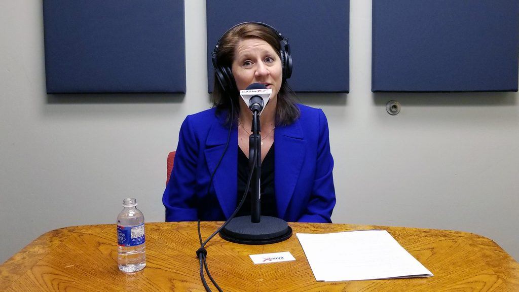 Lisa Riley with LINK Business speaking into a microphone at Valley Business RadioX in Phoenix, Arizona
